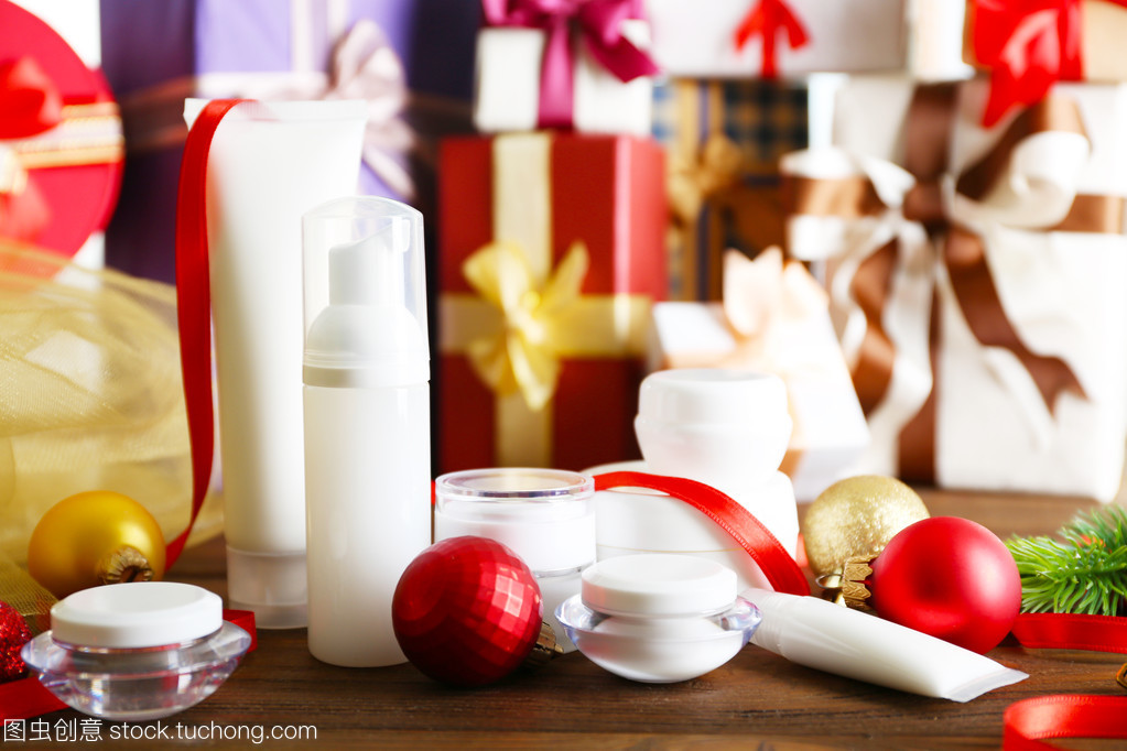 美容化妝品產(chǎn)品與模糊的禮品背景上的圣誕裝飾